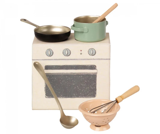a white stove top oven sitting next to a wooden spoon